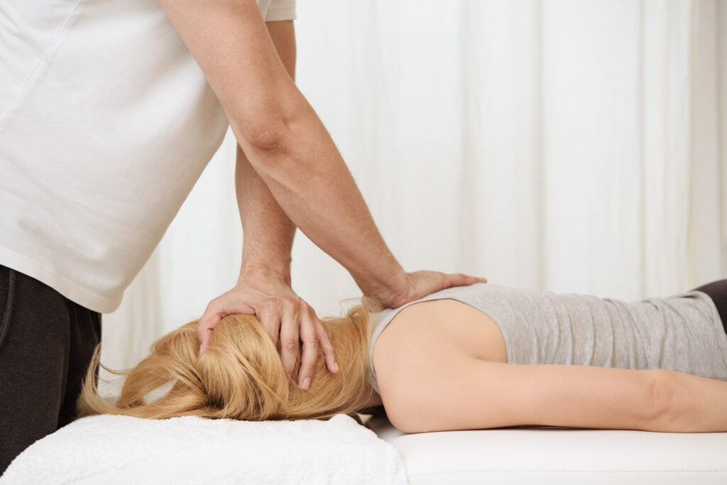 Physiotherapist using chiropractic techniques for back and neck adjustments