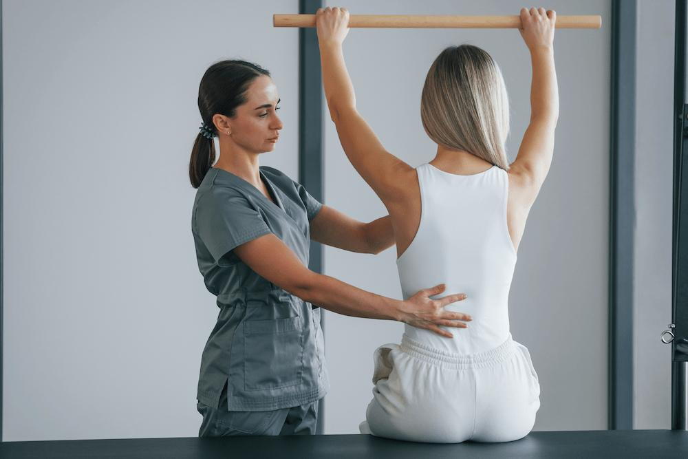 Chiropractor helping a patient to do some stretching and exercise